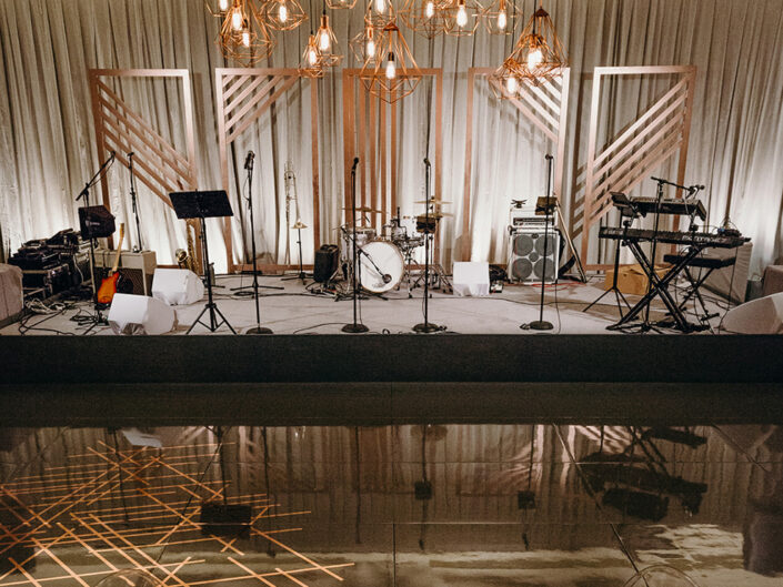 Rose gold geometric metallic detailing on the stage for the post-dinner performance at the wedding.