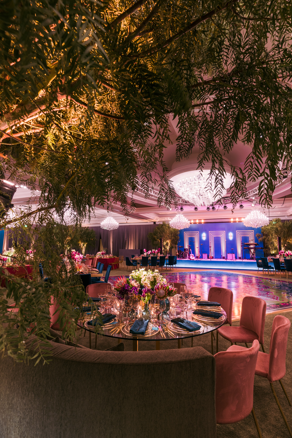 Enchanted garden wedding reception with pepper trees, jewel-toned seating and a patterned dance floor