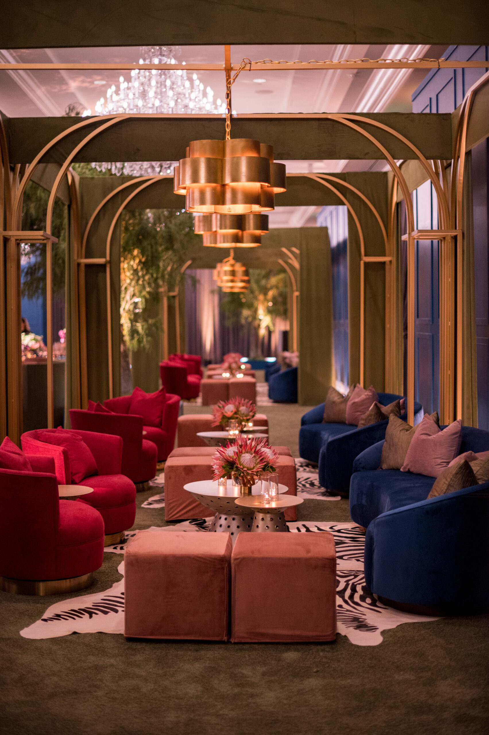 Canopied lounge vignette with velvet seating, animal-print rugs and gold lighting